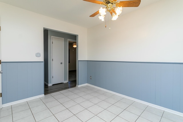 tiled empty room featuring ceiling fan