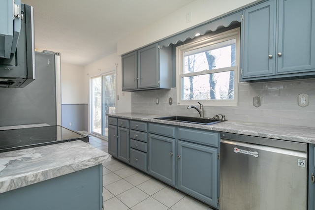 kitchen featuring stainless steel appliances, tasteful backsplash, sink, and light tile patterned floors