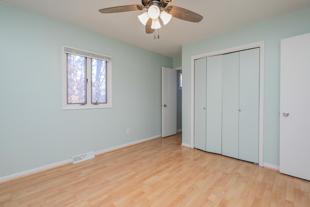 unfurnished bedroom featuring ceiling fan, a closet, and light wood-type flooring