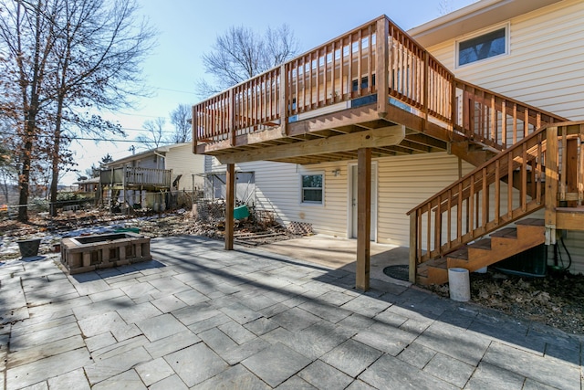 rear view of house with a wooden deck and a patio area