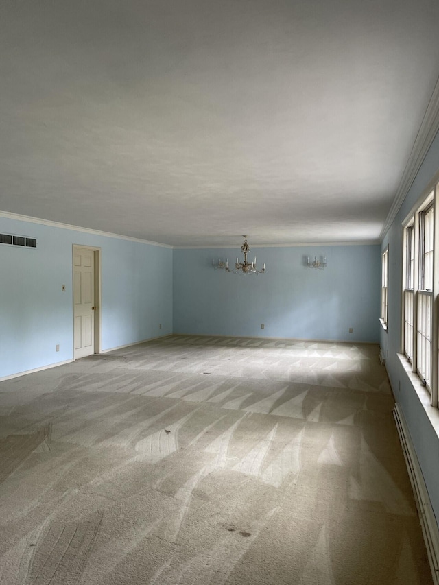 carpeted empty room featuring ornamental molding and a notable chandelier