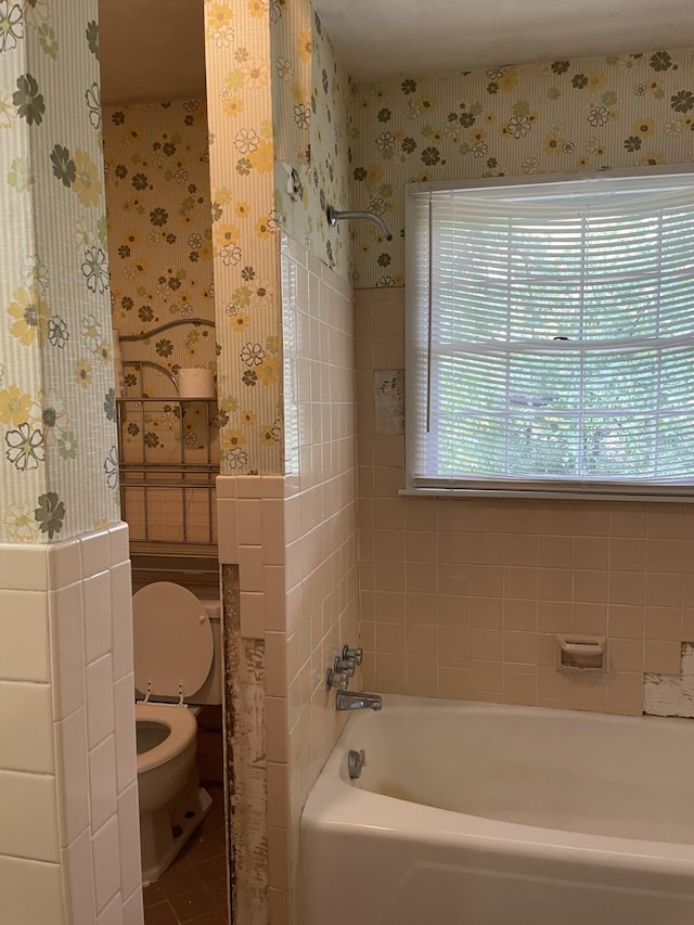 bathroom featuring a bathtub, tile patterned floors, and toilet