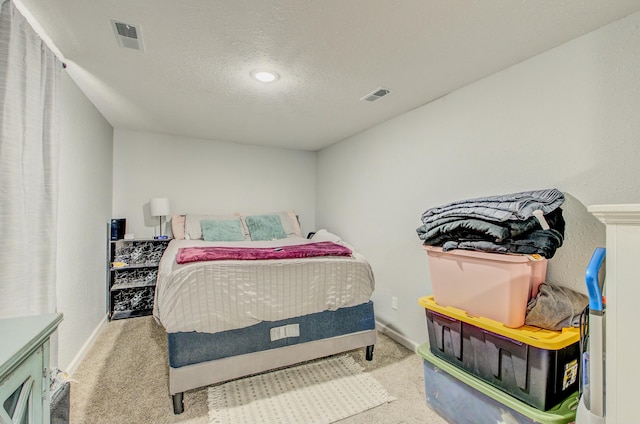 bedroom featuring light carpet and a textured ceiling