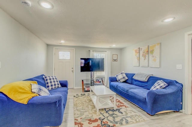 living room featuring a textured ceiling and light wood-type flooring