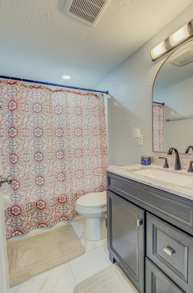 bathroom featuring vanity, toilet, and a textured ceiling