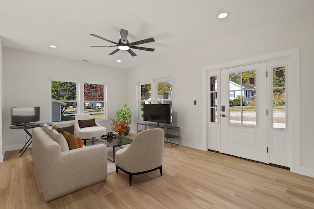 living room with ceiling fan, a wealth of natural light, and light hardwood / wood-style floors