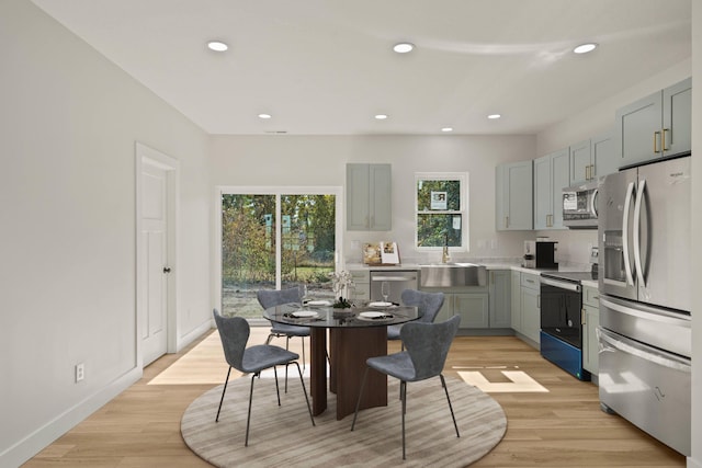 dining area with sink and light wood-type flooring