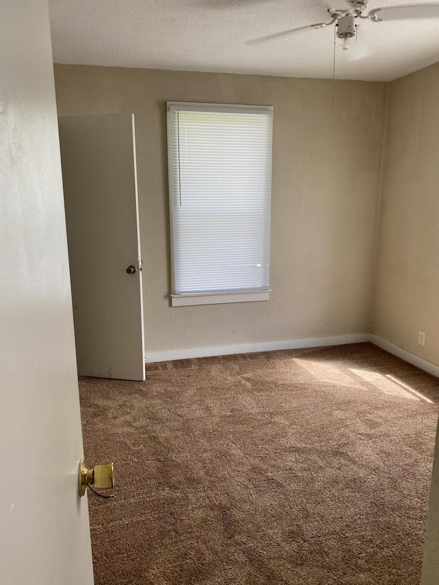 unfurnished room featuring ceiling fan and carpet floors