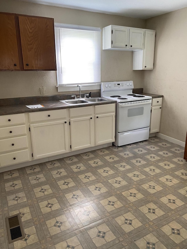 kitchen featuring electric stove, sink, and white cabinetry