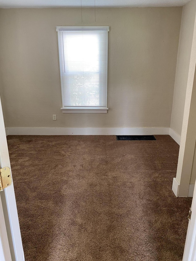 empty room featuring dark colored carpet