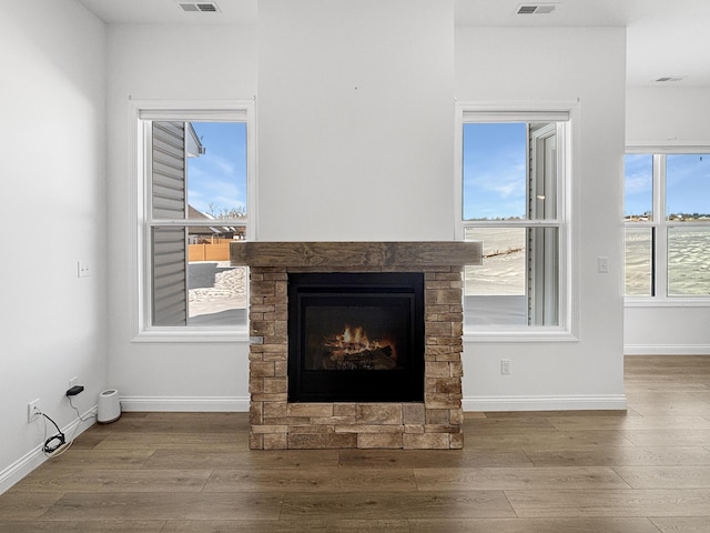 interior details with hardwood / wood-style flooring and a stone fireplace