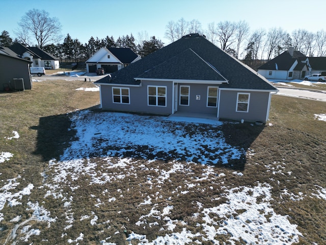 snow covered back of property with a patio