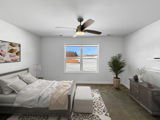 carpeted bedroom featuring ceiling fan and a textured ceiling