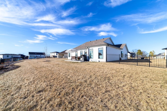 rear view of house featuring a lawn and a patio area