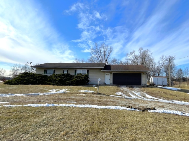 ranch-style house featuring a garage and a front lawn