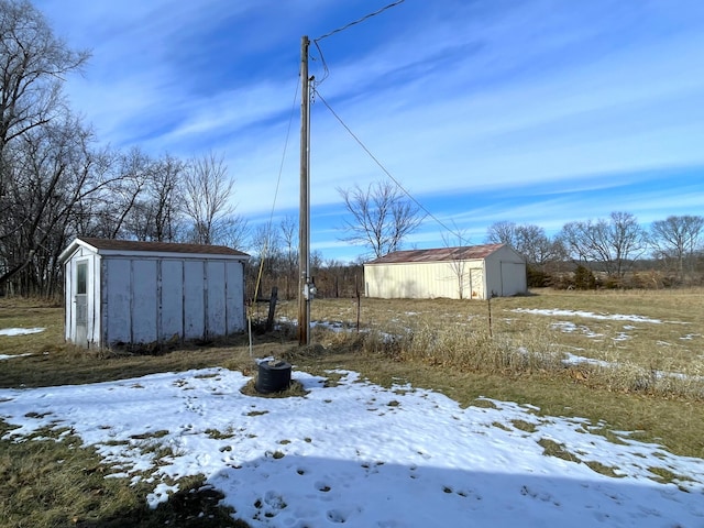 yard layered in snow featuring an outbuilding