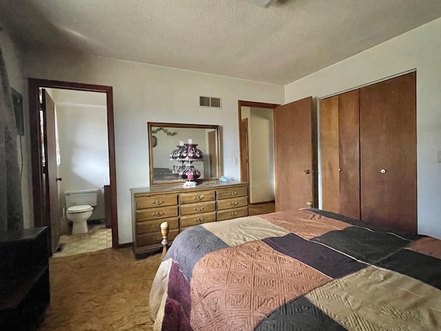 bedroom featuring ensuite bath, carpet flooring, a closet, and a textured ceiling