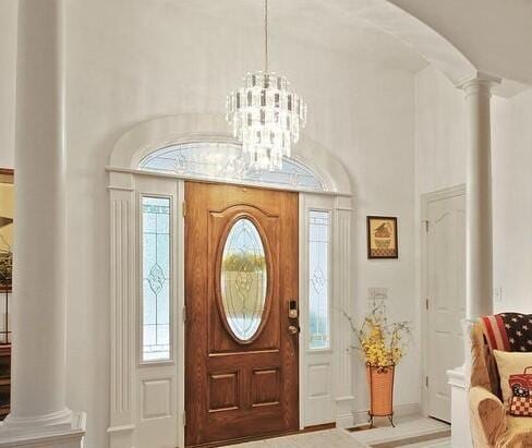 entryway featuring ornate columns and a notable chandelier