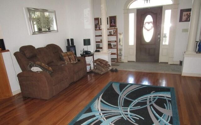 living room with ornate columns and wood-type flooring