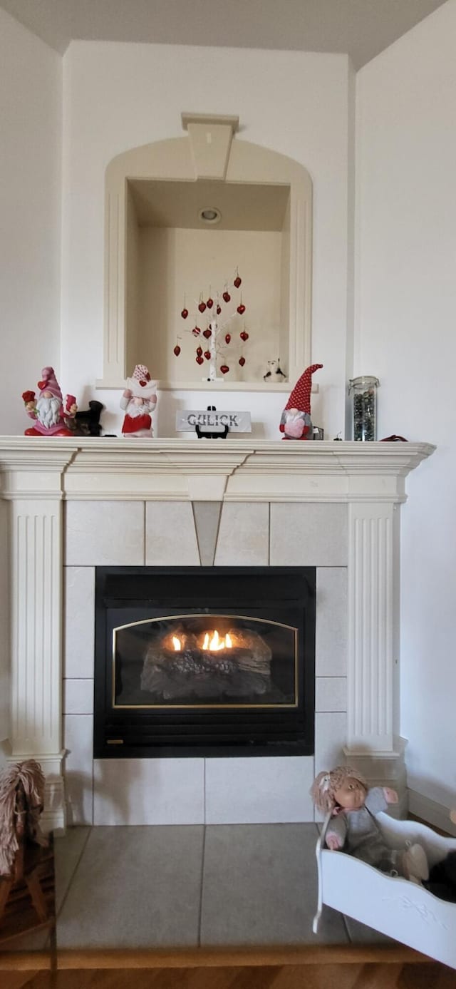 interior details featuring a tile fireplace