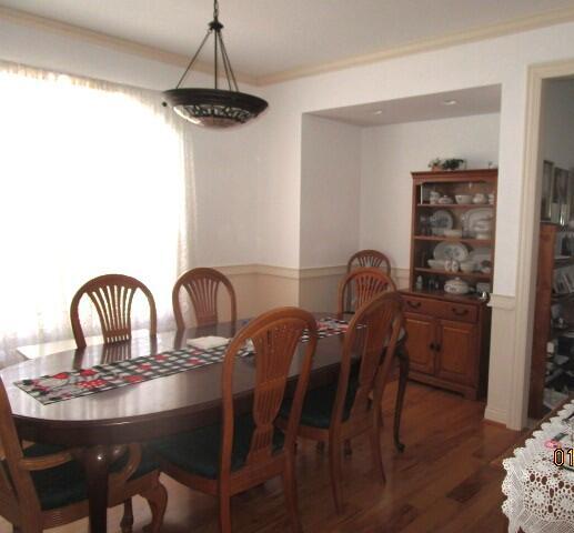 dining area featuring crown molding and dark hardwood / wood-style flooring