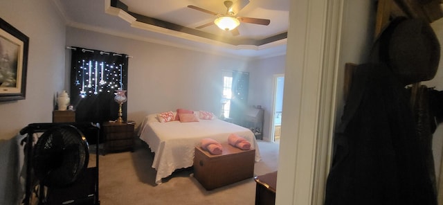 bedroom featuring crown molding, light carpet, ceiling fan, and a tray ceiling