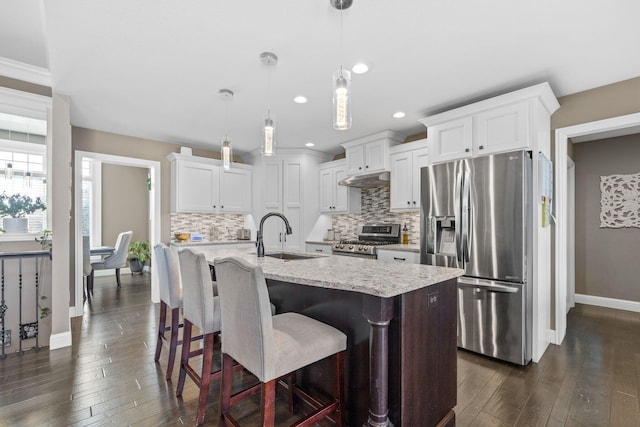 kitchen featuring white cabinetry, stainless steel appliances, decorative light fixtures, and sink