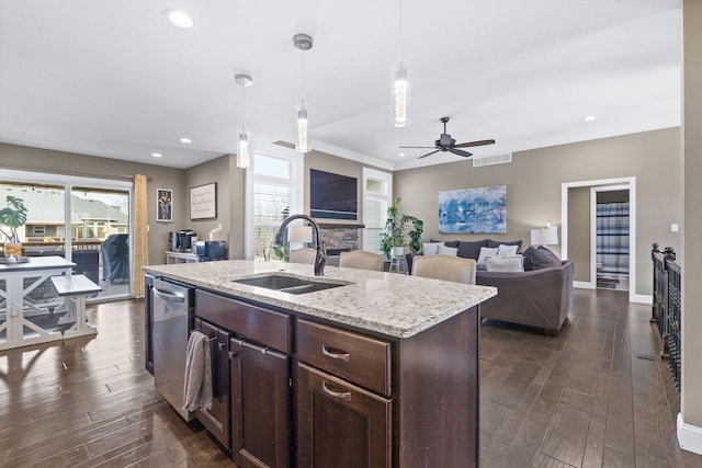 kitchen featuring sink, hanging light fixtures, an island with sink, and dishwasher