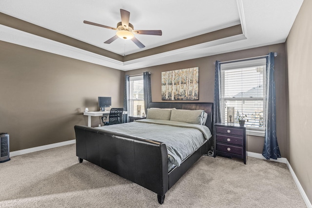 bedroom featuring light carpet, a raised ceiling, and ceiling fan