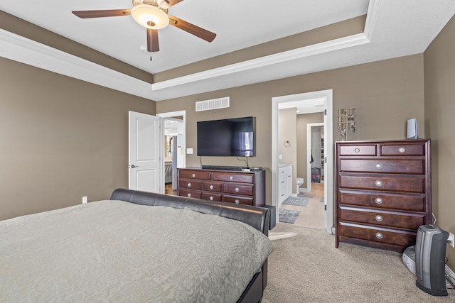 carpeted bedroom with ceiling fan, connected bathroom, and a raised ceiling