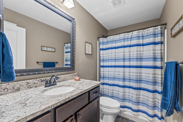 bathroom with a shower with curtain, vanity, a textured ceiling, and toilet