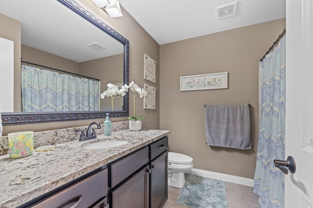 bathroom featuring vanity, toilet, tile patterned flooring, and a textured ceiling