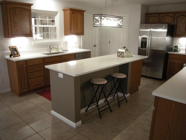 kitchen with stainless steel refrigerator with ice dispenser, a center island, sink, and pendant lighting