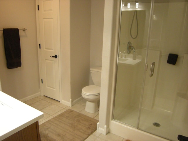 bathroom with vanity, tile patterned flooring, a shower with shower door, and toilet