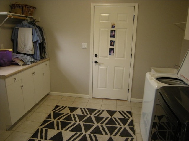 laundry room featuring cabinets, washing machine and dryer, and light tile patterned floors