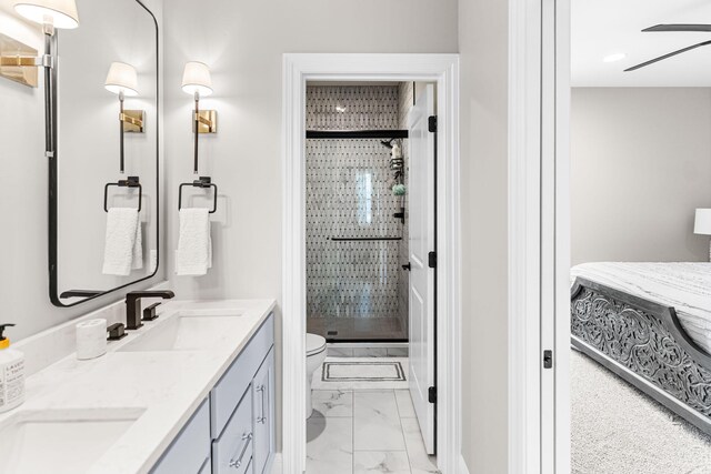 bathroom with ceiling fan, vanity, toilet, and a shower with door