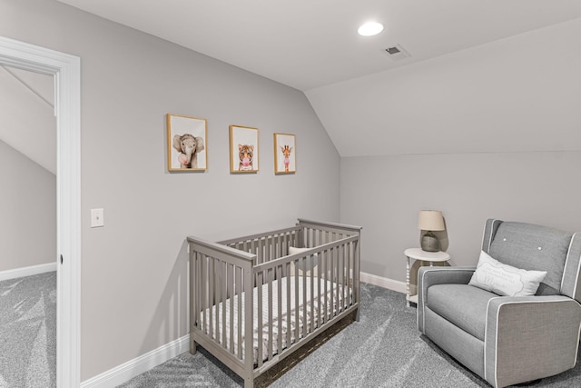 bedroom with vaulted ceiling, a nursery area, and carpet flooring