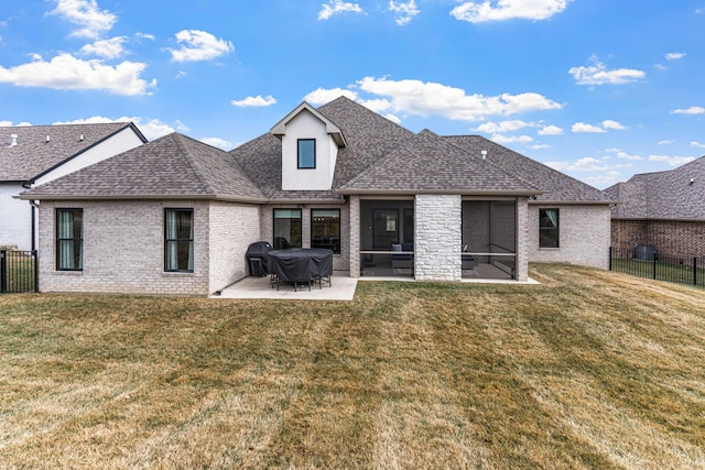 rear view of property with a sunroom, a yard, and a patio area