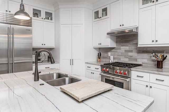 kitchen featuring pendant lighting, premium appliances, sink, and white cabinets