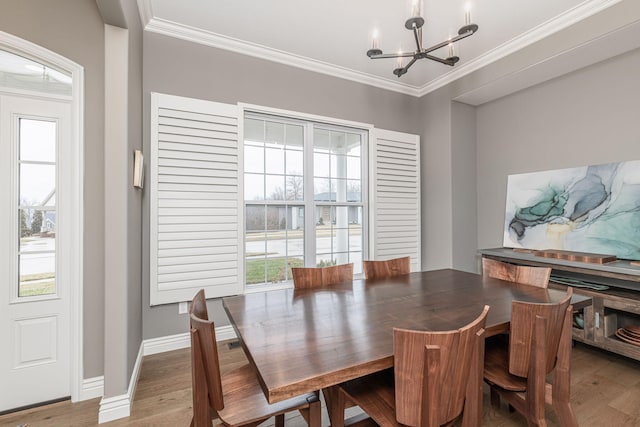 dining space featuring a notable chandelier, crown molding, plenty of natural light, and hardwood / wood-style floors