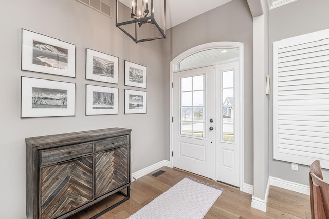 foyer entrance with a notable chandelier and light wood-type flooring