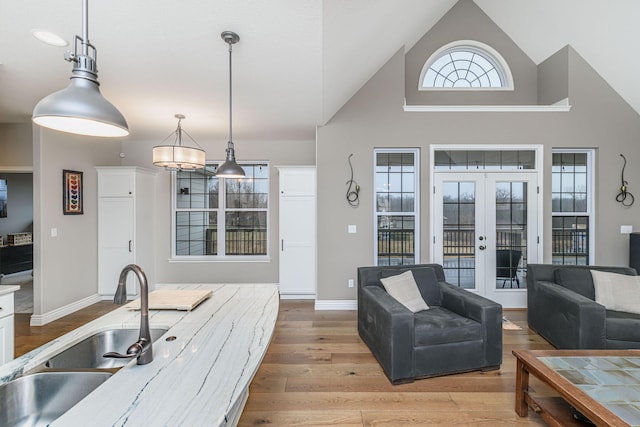 kitchen featuring white cabinetry, sink, pendant lighting, and french doors