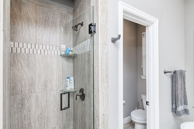 bathroom with a shower with door and toilet