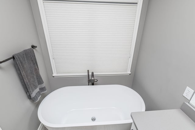 bathroom with vanity and a tub