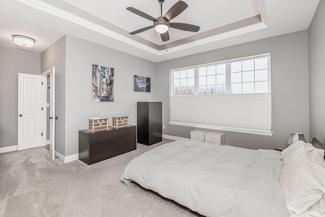 bedroom with a raised ceiling, ornamental molding, carpet, and ceiling fan