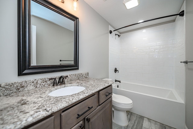 full bathroom featuring wood-type flooring, tiled shower / bath, vanity, and toilet