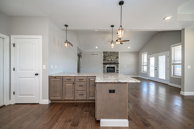 kitchen with pendant lighting, dark hardwood / wood-style floors, and light stone countertops