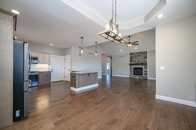 kitchen with decorative light fixtures, appliances with stainless steel finishes, dark hardwood / wood-style flooring, a kitchen island, and ceiling fan