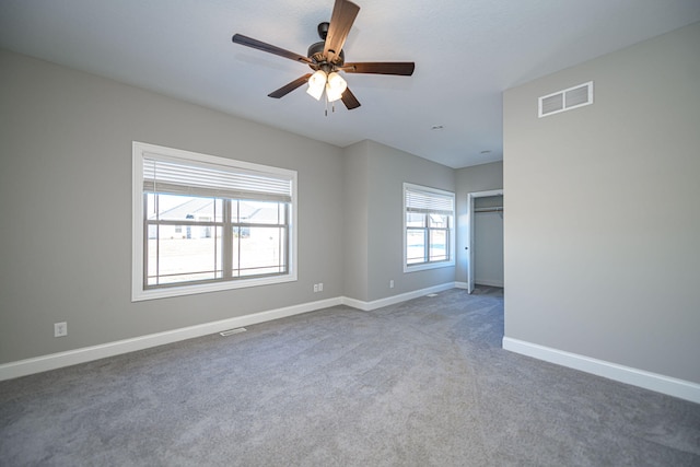 carpeted spare room featuring ceiling fan