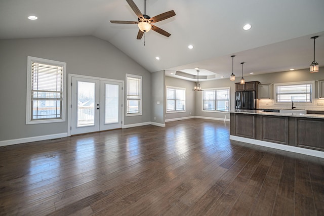 unfurnished living room featuring lofted ceiling, sink, dark hardwood / wood-style floors, and french doors